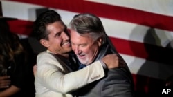 Joe O'Dea, right, Republican nominee to run for the U.S. Senate seat held by Democrat Michael Bennet, is hugged by his son-in-law David Freund on the stage before speaking at a primary election night watch party, June 28, 2022, in Denver. 