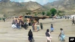En esta imagen tomada de un video de la Agencia Estatal de Noticias Bakhtar, los combatientes talibanes aseguran un helicóptero del gobierno para evacuar a los heridos en el distrito de Gayan, provincia de Paktika, Afganistán, el miércoles 22 de junio de 2022.