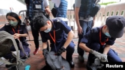 资料照片：2022年6月30日，中国香港警方在香港西九龙火车站外的媒体工作位置检查记者的包。（路透社照片）
