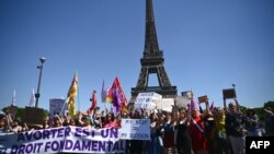 FILE - Demonstrators hold a banner reading "abortion is a basic right" in front of the Eiffel Tower as they take part in a rally calling for right to abortion to be protected by Constitution in Paris, July 2, 2022.