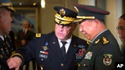 FILE - U.S. Joint Chiefs Chairman Gen. Mark Milley introduces members of his staff to China's People's Liberation Army Gen. Li Zuocheng during a welcome ceremony at the Bayi Building in Beijing, Aug. 16, 2016.