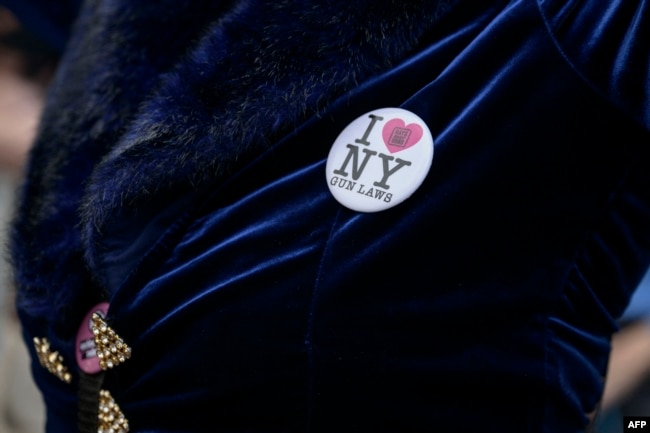 A protester wears a button reading