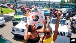 FILE - Jasmine Kingi, left, 26, and Robin Renee Green, 26, both from Los Angeles, celebrate as they take part in a car parade to mark Juneteenth, on June 19, 2021, in Inglewood, Calif. Juneteenth commemorates the effective end of slavery in the U.S.