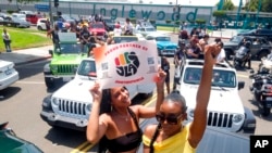 ARCHIVO - Jasmine Kingi, izquierda, 26, y Robin Renee Green, 26, ambas de Los Ángeles, celebran mientras participan en un desfile de autos para conmemorar Juneteenth, el 19 de junio de 2021, en Inglewood, California.