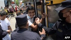 Personas detenidas por supuestos vínculos con pandillas son escoltadas por la Policía Nacional Civil durante el estado de emergencia declarado por el gobierno salvadoreño en el centro penal de San Salvador el 25 de abril de 2022.