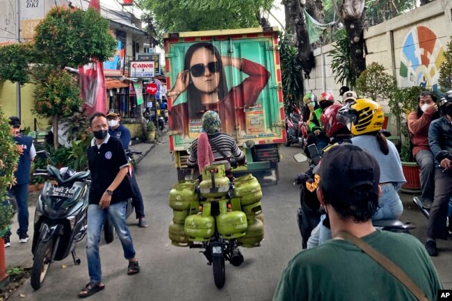 People make their way through a crowded street in Jakarta, Indonesia, in this Saturday, Feb 5, 2022 iPhone photo, taken by Dita Alangkara. (AP Photo/Dita Alangkara)