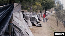 ARCHIVO - Migrantes venezolanos se cepillan los dientes en un campamento improvisado cerca de una estación de autobuses en Quito, en septiembre de 2018.