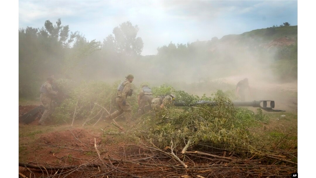 Tentara Ukraina menyembunyikan howitzer M777 yang dipasok AS dengan ranting pepohonan setelah mereka menembaki posisi Rusia di wilayah Donetsk timur Ukraina pada Sabtu, 18 Juni 2022. (Foto: AP)