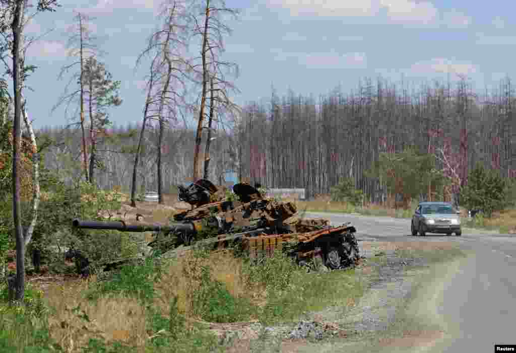 A destroyed tank sits alongside a road near the city of Sievierodonetsk in the Luhansk area of Ukraine.