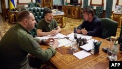This handout picture taken and released by Ukraine's presidential press-service on June 28, 2022 shows the Ukrainian President Volodymyr Zelensky, center, talking with US actor Sean Penn, right, next to Ukraine official Andriy Yermak during their meeting