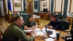 Ukrajinski predsednik Volodimir Zelenski, u sredini, kako razgovara sa američkim glumcem Šonom Penom, desno, pored ukrajinskog zvaničnika Andrija Jermaka, tokom sastanka u Kijevu, 28. juna 2022.