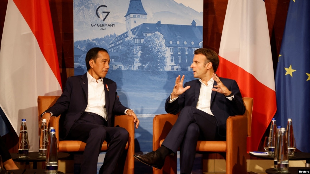Presiden Prancis Emmanuel Macron (kanan) berbincang dengan Presiden Joko Widodo sebelum pelaksanaan diskusi bilateral di KTT G7 di Jerman, pada 27 Juni 2022. (Foto: Pool via Reuters/Ludovic Marin)