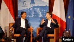 Presiden Prancis Emmanuel Macron (kanan) berbincang dengan Presiden Joko Widodo sebelum pelaksanaan diskusi bilateral di KTT G7 di Jerman, pada 27 Juni 2022. (Foto: Pool via Reuters/Ludovic Marin)