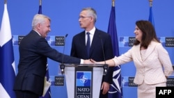 Finnish Foreign Minister Pekka Haavisto shakes hands with Swedish Ministry for Foreign Affairs Ann Linde next to NATO Secretary-General Jens Stoltenberg following a press conference in Brussels, July 5, 2022.