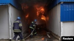 우크라이나 슬로뱐스크에서 소방관들이 포격으로 발생한 화재를 진압하고 있다. 