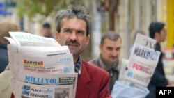 FILE - Azeri street vendors sell papers in downtown Baku, in November 2005. President Ilham Aliyev on Sept. 26, 2022, signed off on new “rules for maintaining a media registry” in the country.  