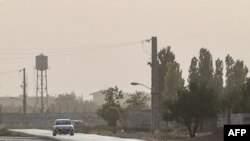 This picture taken on July 4, 2022 shows a vehicle driving through heavy haze during a sandstorm in the south of Iran's capital Tehran. 