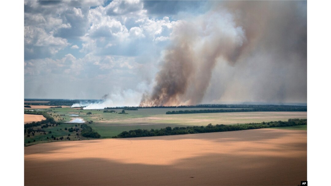 Smoke rises from the front lines where fierce battles are raging going between Ukrainian and Russian troops, with agricultural fields in the foreground, in Ukraine's Dnipropetrovsk region, July 4, 2022.
