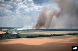 Smoke rises from the front lines where fierce battles are raging going between Ukrainian and Russian troops, with agricultural fields in the foreground, in Ukraine's Dnipropetrovsk region, July 4, 2022.