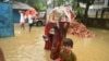 Members of a flood-affected family leave their home in the Gowainghat subdistrict of Sylhet district, Bangladesh, and head toward a flood shelter. (Md Serajul Islam/VOA)