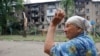 Жінка жестикулює біля житлового будинку, пошкодженого під час обстрілів у Донецьку, на території підвладної Донецької Народної Республіки, на сході України, 22 червня 2022 року.