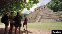 -Turistas buscan sombra cerca de una de las antiguas pirámides de la ciudad maya de Palenque, en el estado de Chiapas, al sur de México. [Archivo]