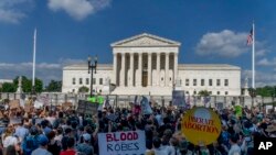 Para pendukung hak-hak aborsi dan penentang aborsi menunggu putusan Mahkamah Agung AS di depan gedung Mahkamah Agung di Washington, DC Jumat (24/6).