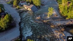 A house sits in Rock Creek after floodwaters washed away a road and a bridge in Red Lodge, Mont., June 15, 2022.