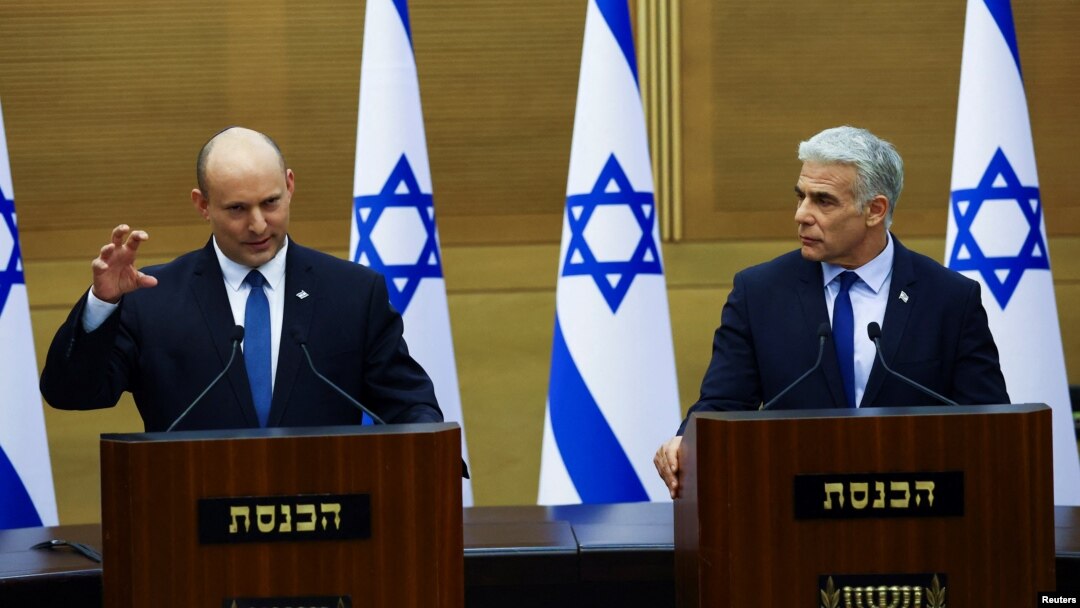 PM Israel Naftali Bennett (kiri) bersama sekutunya Menlu Yair Lapid mengumumkan akan dibubarkankannya pemerintahan koalisi, di Yerusalem hari Senin (20/6). 