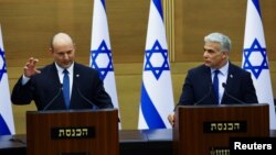 PM Israel Naftali Bennett (kiri) bersama sekutunya Menlu Yair Lapid mengumumkan akan dibubarkankannya pemerintahan koalisi, di Yerusalem hari Senin (20/6). 