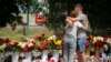 People lay flowers to pay last respects to victims of the Russian rocket attack at a shopping center in Kremenchuk, Ukraine, June 29, 2022. 