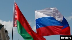 FILE - Belarusian and Russian national flags fly during a "Day of Multinational Russia" event in central Minsk, Belarus, June 8, 2019.