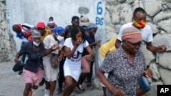 FILE - People who were marching to the prime minister's residence, to demand justice for the assassination of Haitian President Jovenel Moise, run from tear gas fired by police in Port-au-Prince, Haiti, Oct. 20, 2021.