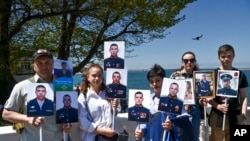 Familiares de soldados rusos que han muerto en la guerra de Ucrania muestran sus fotos en Sebastopol, Crimea, el 9 de mayo de 2022.