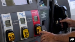 FILE - A customer pumps gas at an Exxon gas station, May 10, 2022, in Miami. 