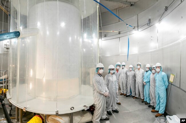 This photo provided by Sanford Underground Research Facility shows members of the LZ team in the LZ water tank after the outer detector installation in Lead, S.D. (Matthew Kapust/Sanford Underground Research Facility via AP)