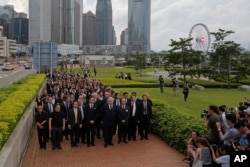 FILE - Hundreds of legal professionals wear black to express their disappointment as they participate in a silent march to protest against the extradition bill in Hong Kong on June 6, 2019. (AP Photo/Kin Cheung, File)