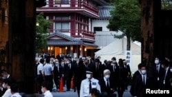 Officials and mourners attend the vigil for late former Japanese Prime Minister Shinzo Abe, who was shot while campaigning for a parliamentary election, at Zojoji Temple, in Tokyo, July 11, 2022. 