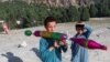 Seorang anak laki-laki Afghanistan bermain dengan mainan RPG buatan sendiri di daerah yang baru saja dilanda gempa di distrik Spera di provinsi Khost. (Foto: Reuters)