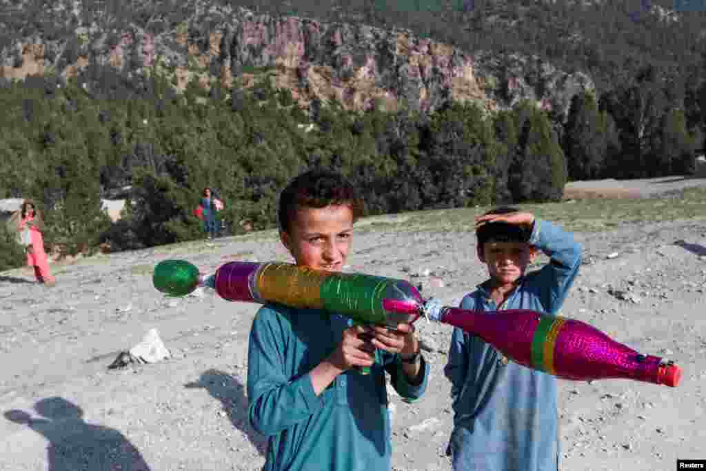 Seorang anak laki-laki Afghanistan bermain dengan mainan RPG buatan sendiri di daerah yang baru saja dilanda gempa di distrik Spera di provinsi Khost. (Foto: Reuters)