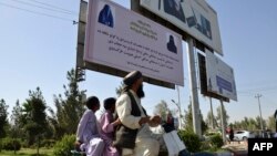 طالبان در این بلبورد نوشته اند که نشانۀ امتیازی زن مسلمان و غیرمسلمان حجاب است