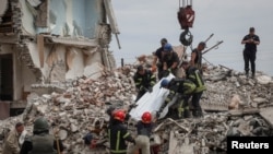 Rescuers extract a body from a residential building hit by a Russian missile, amid Russia's invasion on Ukraine, in the town of Chasiv Yar, Donetsk region, eastern Ukraine, July 10, 2022.