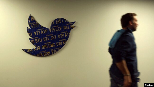 FILE - An employee walks past a Twitter logo made from California license plates at the company's headquarters in San Francisco, California October 4, 2013. (REUTERS/Robert Galbraith/File Photo)