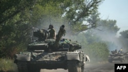 Ukrainian troops move by tanks on a road of the eastern Ukrainian region of Donbas, June 21, 2022. Ukraine said Russian shelling had caused "catastrophic destruction" in the eastern industrial city of Lysychansk. Regional governor Sergiy Gaiday said shelling of Lysychansk on June 20 destroyed 10 residential blocks and a police station, killing at least one person.