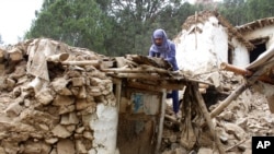 Un aldeano afgano recoge sus pertenencias de debajo de los escombros de su casa que fue destruida por un terremoto en el distrito de Spera, en la parte suroeste de la provincia de Khost, Afganistán, el 22 de junio de 2022.