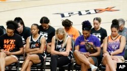 Phoenix Mercury players bow their heads in prayer during a rally for WNBA basketball teammate Brittney Griner on July 6, 2022, in Phoenix. Griner has been detained in Russia since mid-February.