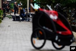 Law enforcement search in downtown Highland Park, Ill., a Chicago suburb, after a mass shooting at the Highland Park Fourth of July parade, July 4, 2022.