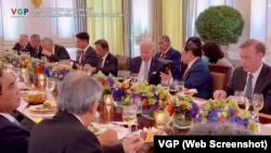 Thủ tướng Việt Nam Phạm Minh Chính trò chuyện với Tổng thống Mỹ Joe Biden trong khi các vị khách khác dùng bữa tối trong Phòng Quốc Yến tại Nhà Trắng, ở Washington, ngày 12 tháng 5 năm 2022. Ảnh chụp màn hình video do Báo Điện tử Chính phủ đăng tải.