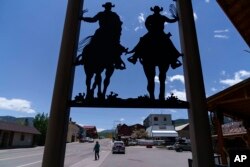 A pedestrian walks through Gardiner, Montana, which relies heavily on tourism for its economy as it sits at the entrance to Yellowstone National Park, June 15, 2022.