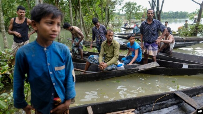 Flood affected people wait to receive relief material in Sylhet, Bangladesh, Wednesday, June 22, 2022. (AP Photo/Mahmud Hossain Opu)